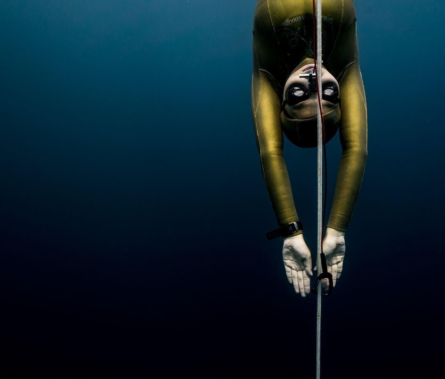 A freediver descending a line into the deep — Amed's calm, quickly-deep water makes it Bali's main freediving hub.