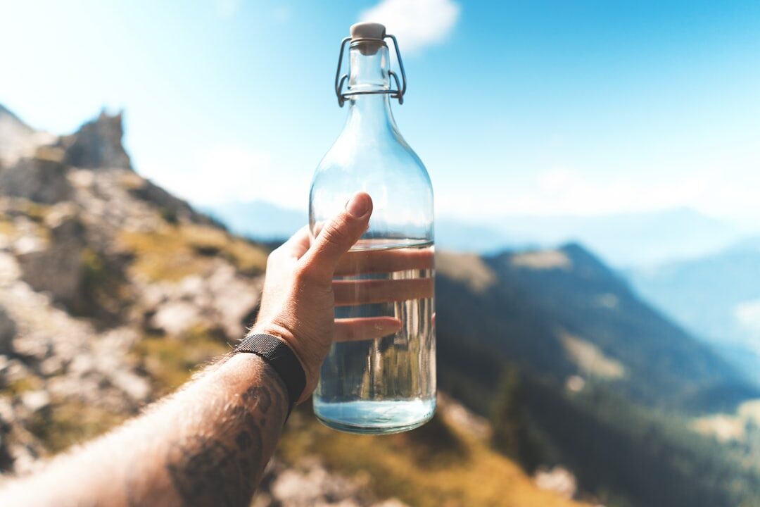 Clean drinking water in hand out on the trail — bottled or filtered, never straight from the tap.