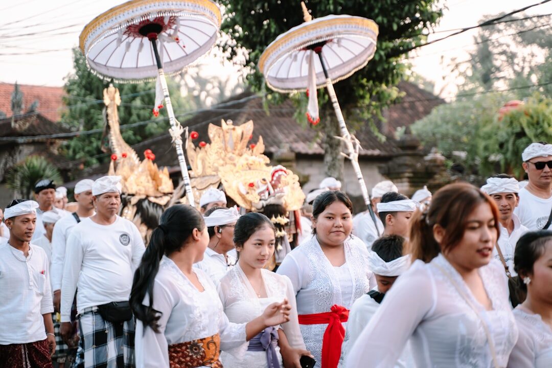 The crowd at a ceremony under ceremonial parasols, everyone in white. A few quiet rules make you a good guest rather than an intrusion.