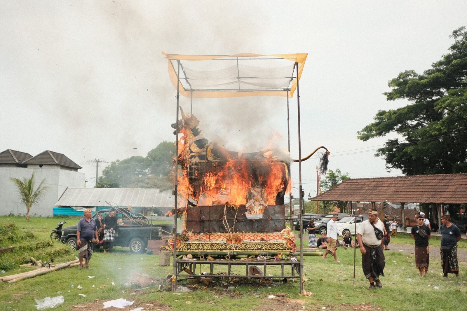The cremation itself: the tower alight in an open field as the family looks on.