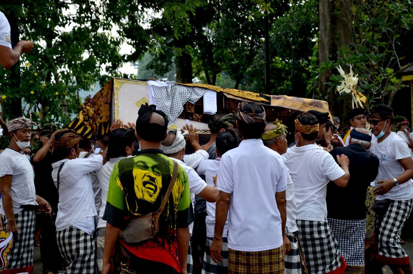 The crowd gathered around the cremation structure — a whole community shares the day and its cost.