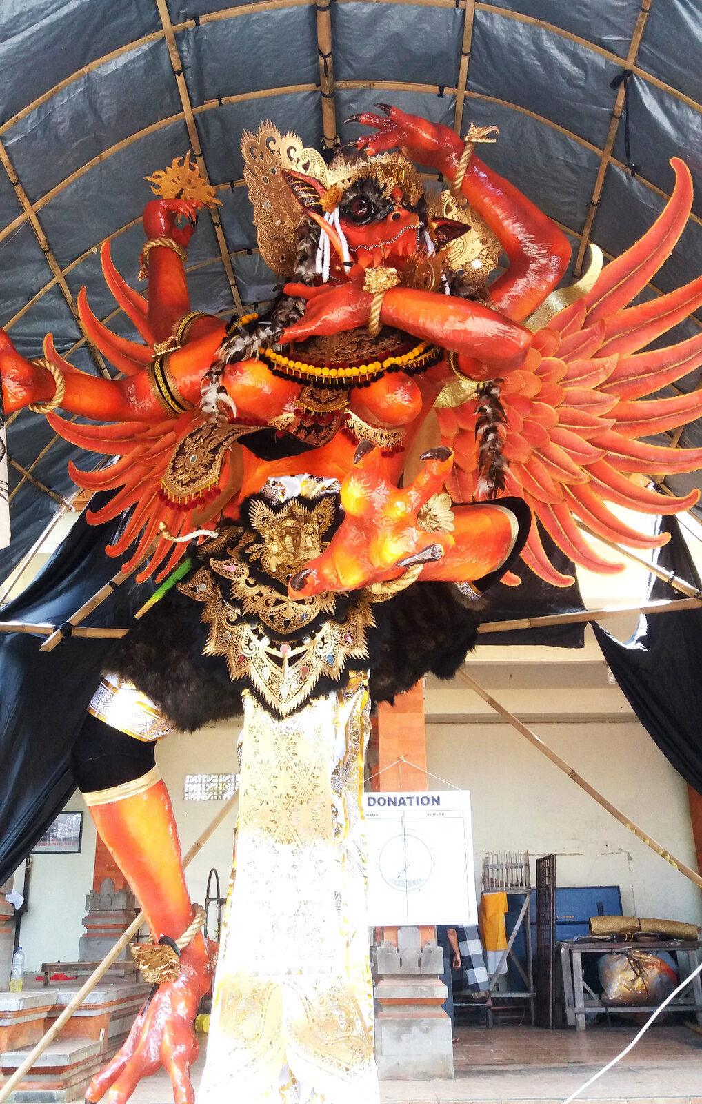 A winged, fiery ogoh-ogoh waiting in its shelter before the parade — weeks of work by the local youth group.