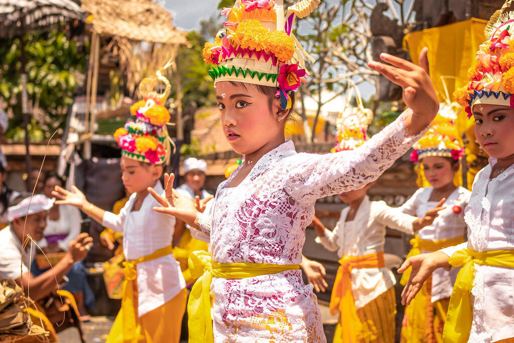 Dancers in gilt crowns at the head of a ceremony — the everyday face of Bali's ceremonial calendar.