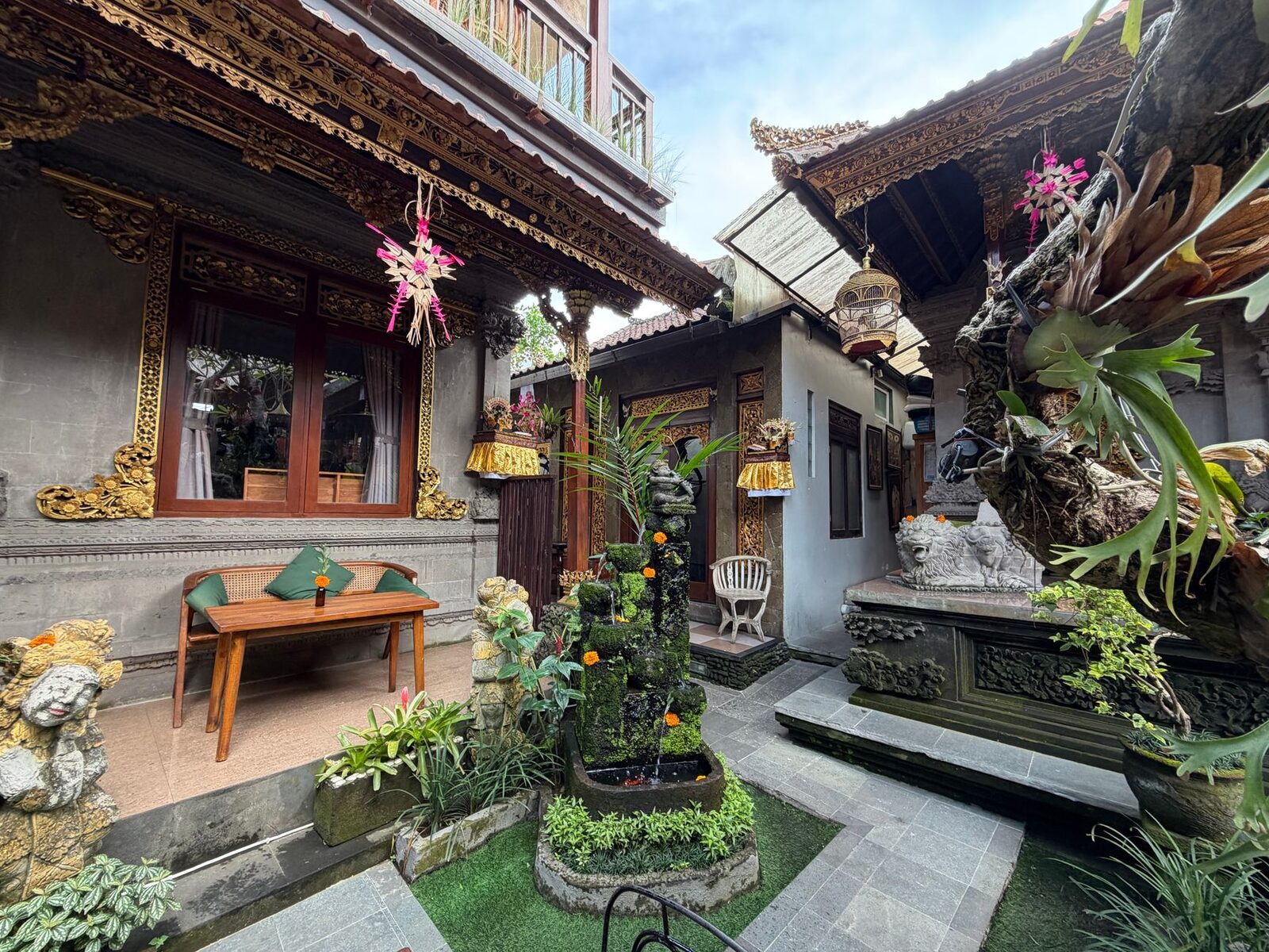 A family homestay courtyard — a simple room off a carved compound and a garden like this, at a weekly rate, is the single biggest saving on a Bali trip.