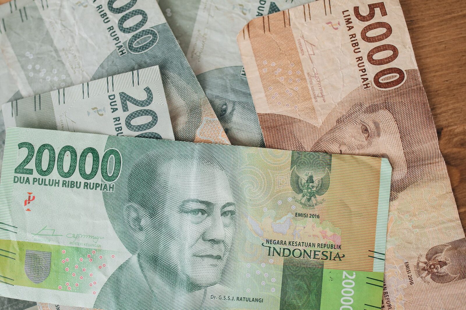Indonesian rupiah up close — the 20,000 and 5,000 notes. Knowing roughly what a stack should look like is half the defence against a short-count.