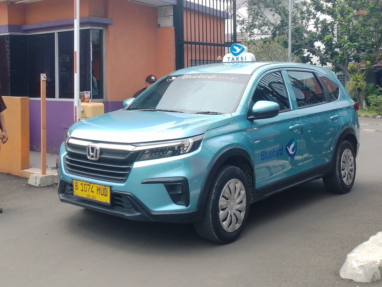 A metered blue taxi on a Bali street. If you do end up in a car with no working meter, agree the full fare out loud before you move — never at the destination. Tap any image for its source and licence.