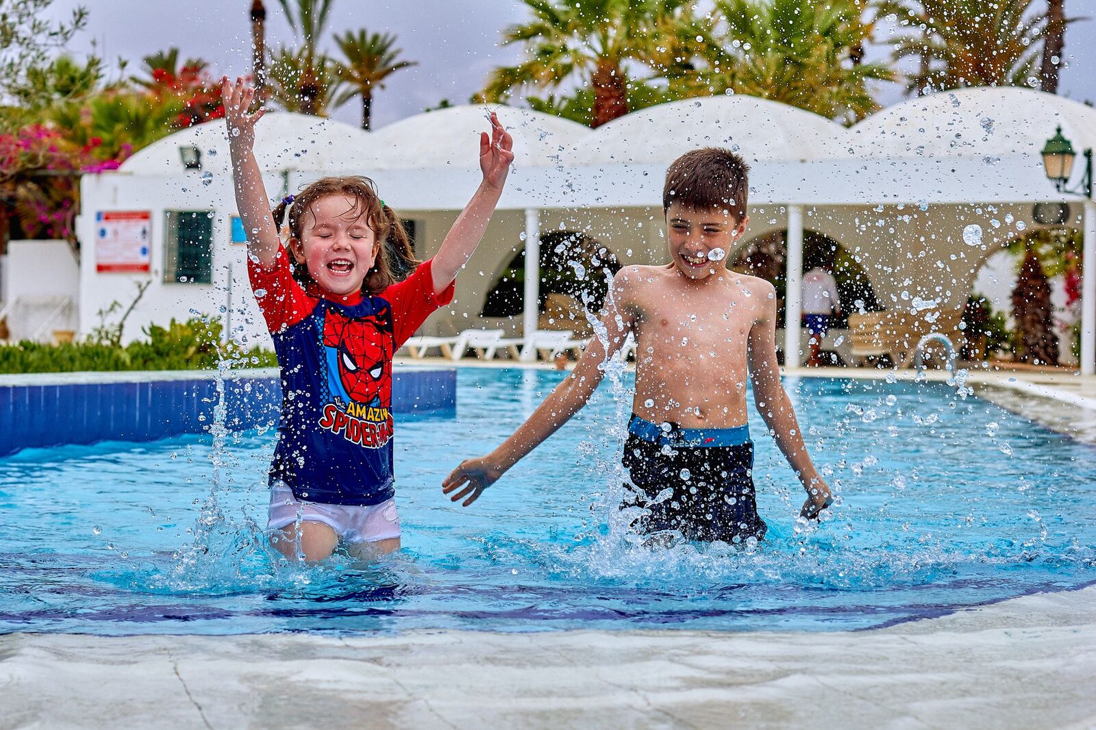 Kids splashing in a resort pool — the pool is where a Bali holiday with children really happens.