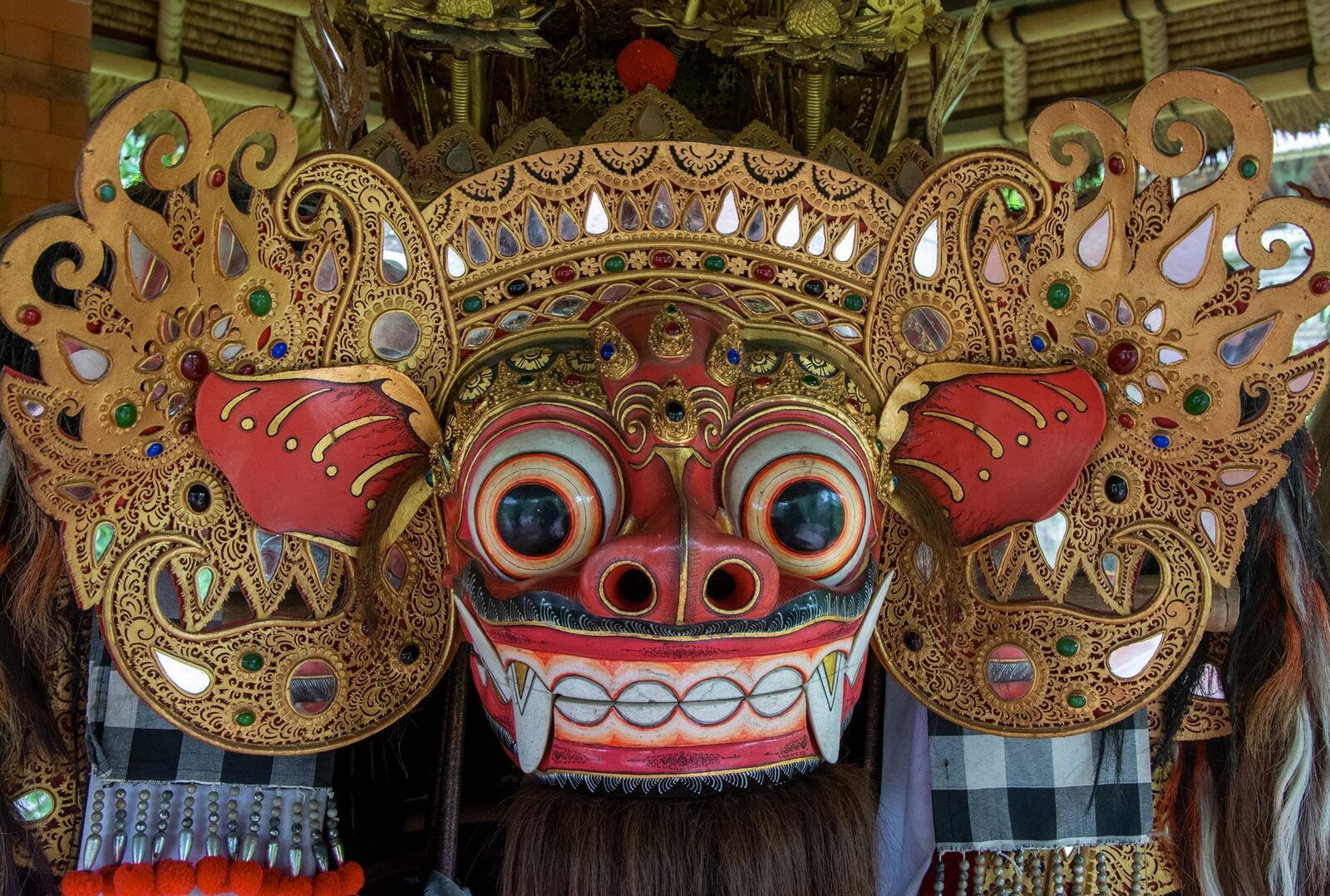 The Barong's mask up close: bulging eyes, gilded crest, mirror-work.