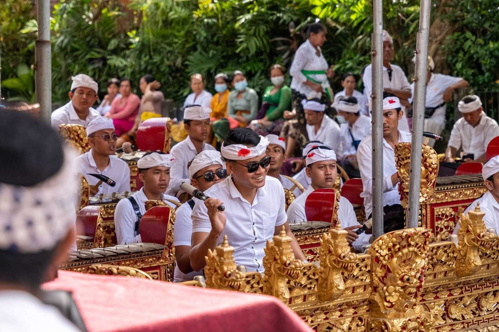 A full gamelan ensemble seated in rows, gongs and metallophones ranged in front of them.