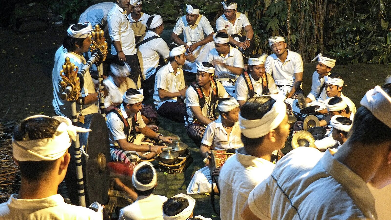 A seated gamelan ensemble tuning up before a performance.