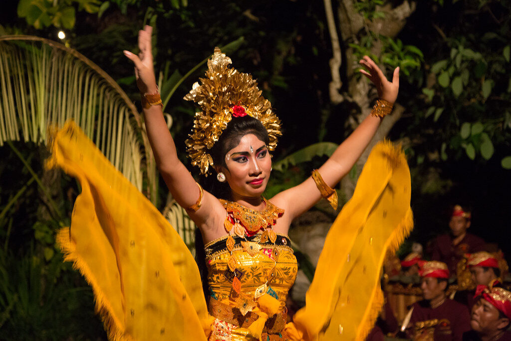 A dancer sweeping a length of silk, headdress catching the light.