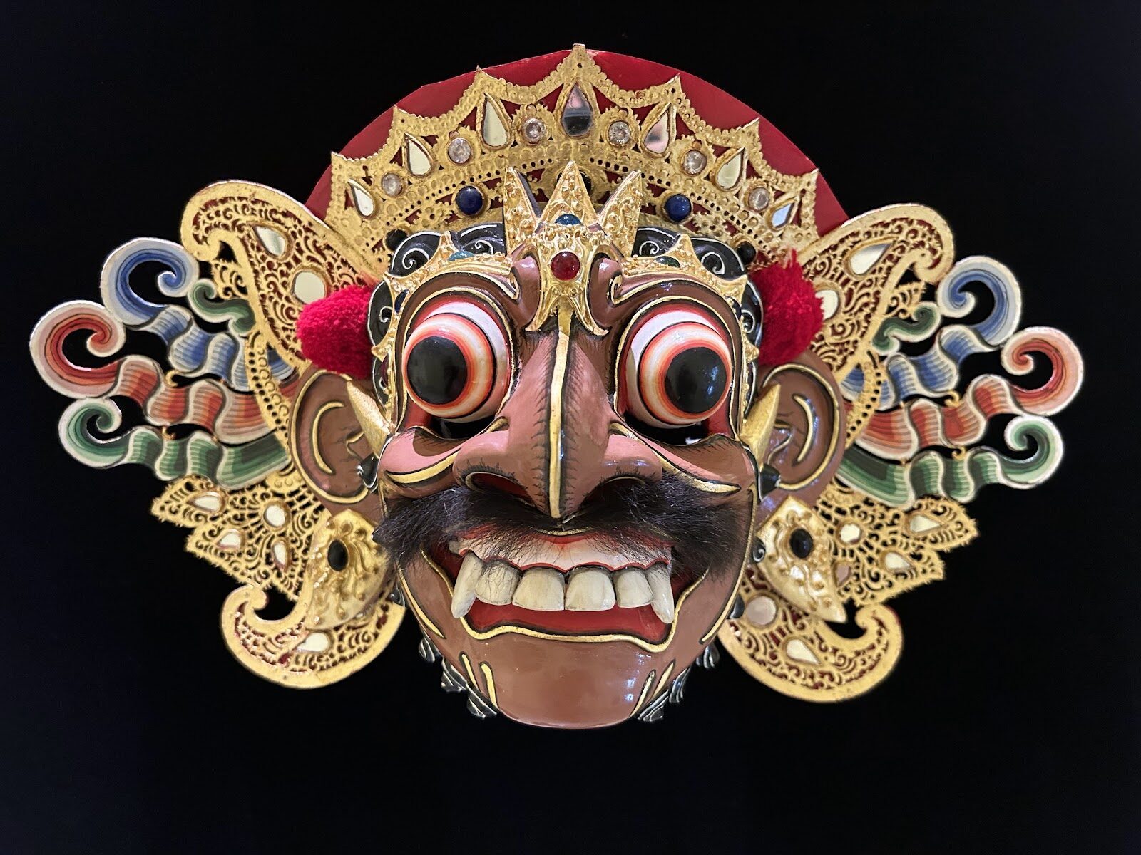 A carved Balinese dance mask, gilded and painted.