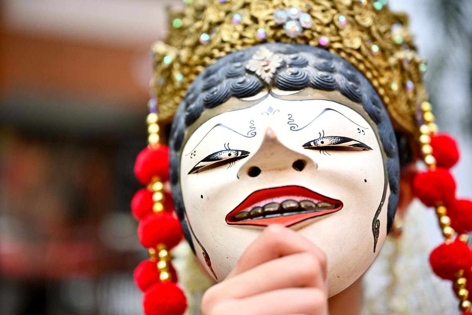 A white-faced dance mask worn in performance.