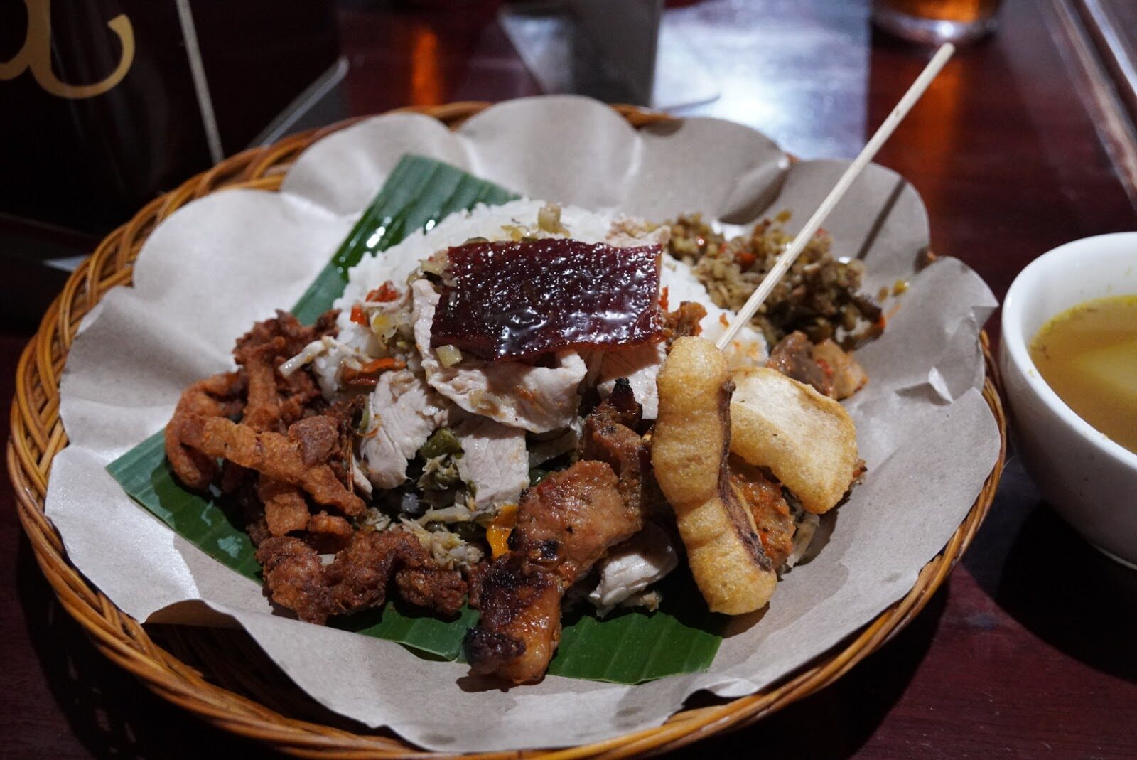 Nasi campur — a scoop of rice ringed with small portions of the day's cooking, the everyday way to taste ten things at once.