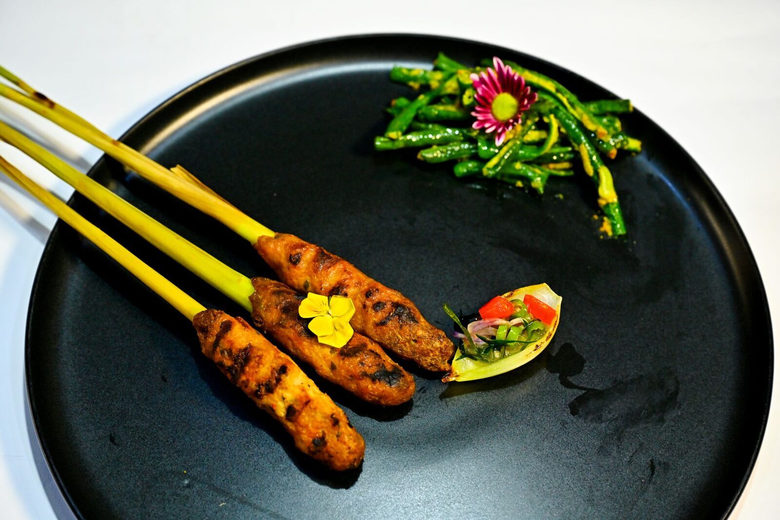 Sate lilit — minced fish blended with spice paste and coconut, moulded onto skewers and grilled. Bali's own satay.