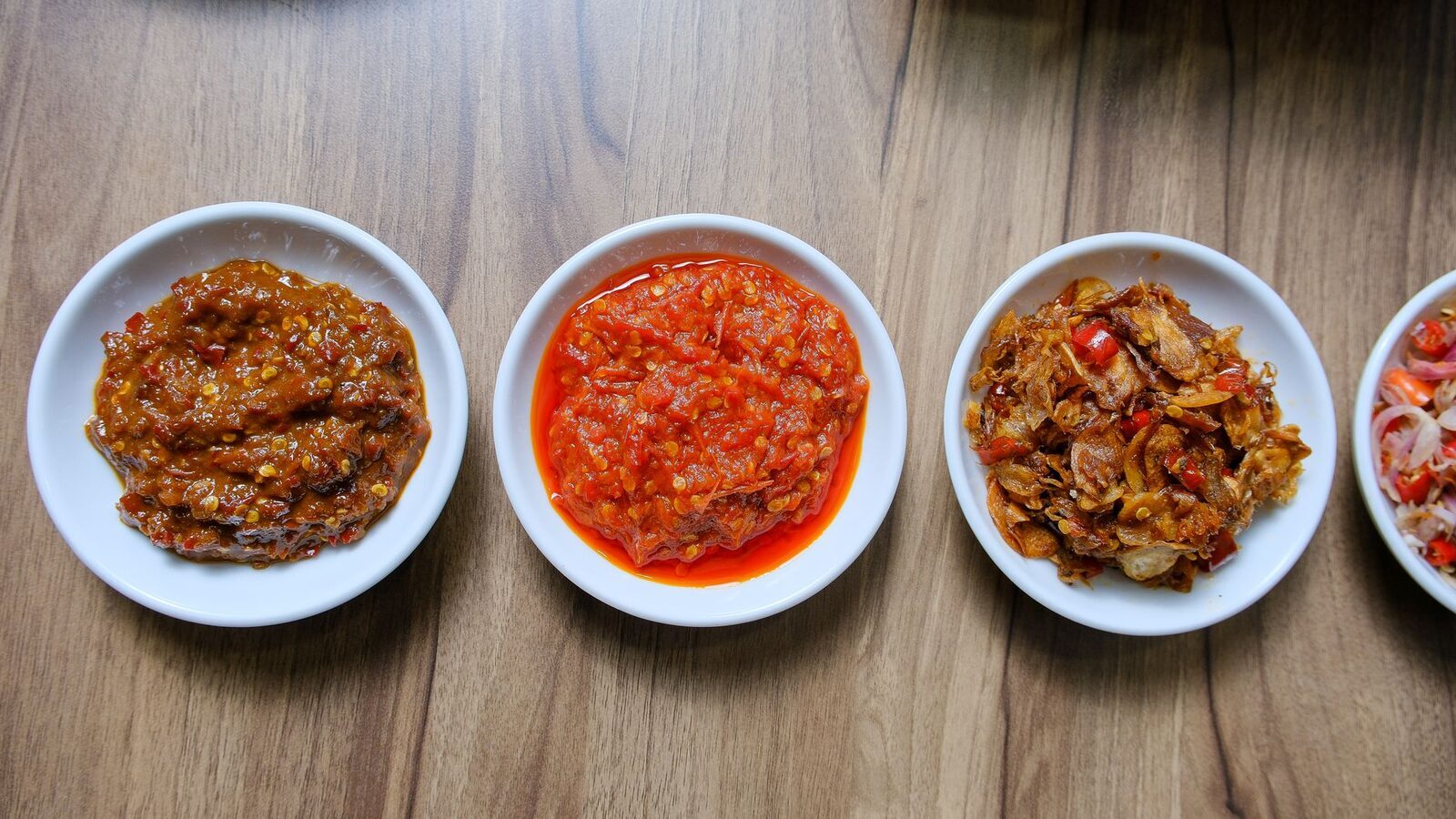Bowls of Balinese sambal and base gede — the pounded spice paste that flavours nearly every savoury dish here.