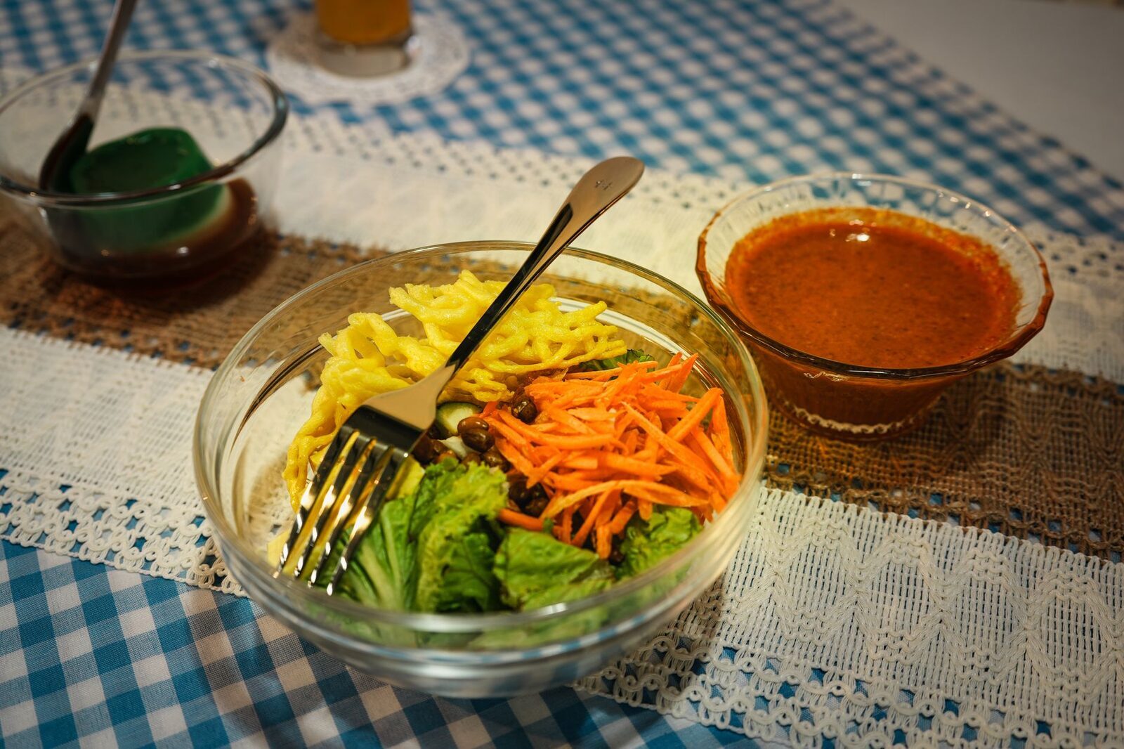 Vegetables and carrot ribbons with peanut sauce on the side.