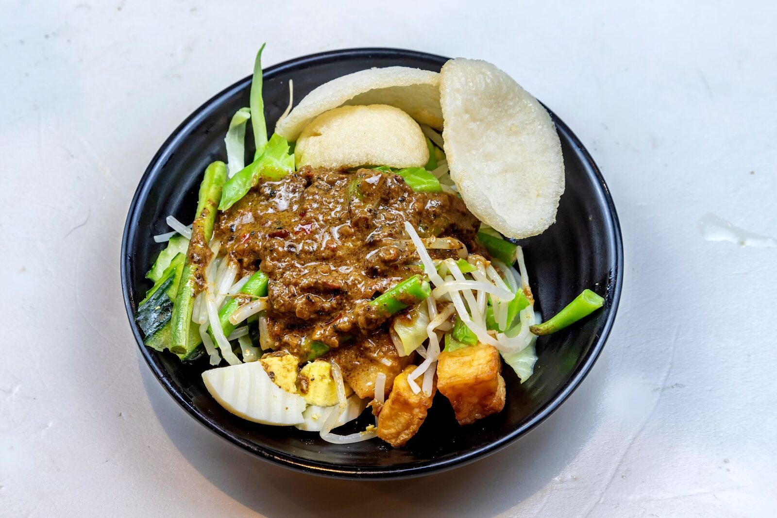 Gado-gado — blanched vegetables, tofu, egg and crackers under a warm peanut sauce.