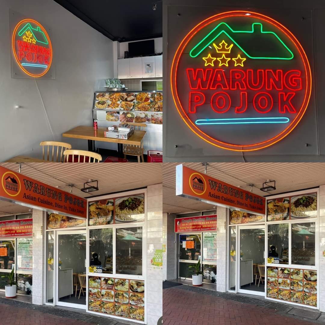 A warung storefront, its glass case of cooked dishes lit up out front.