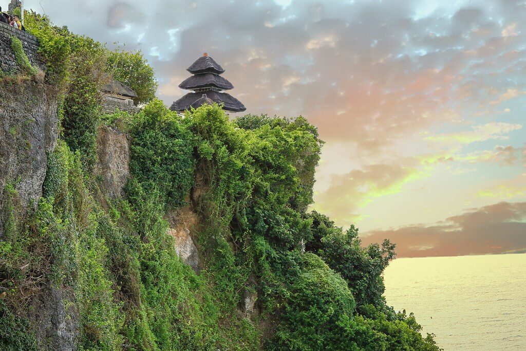 Uluwatu toward dusk, the cliff dropping straight to the surf below.