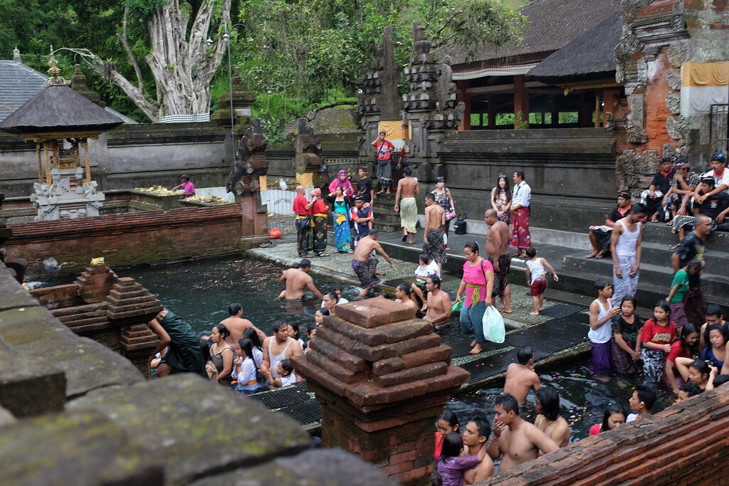 The crowd at a spring like Tirta Empul near Ubud, where families bring their children for the rite.