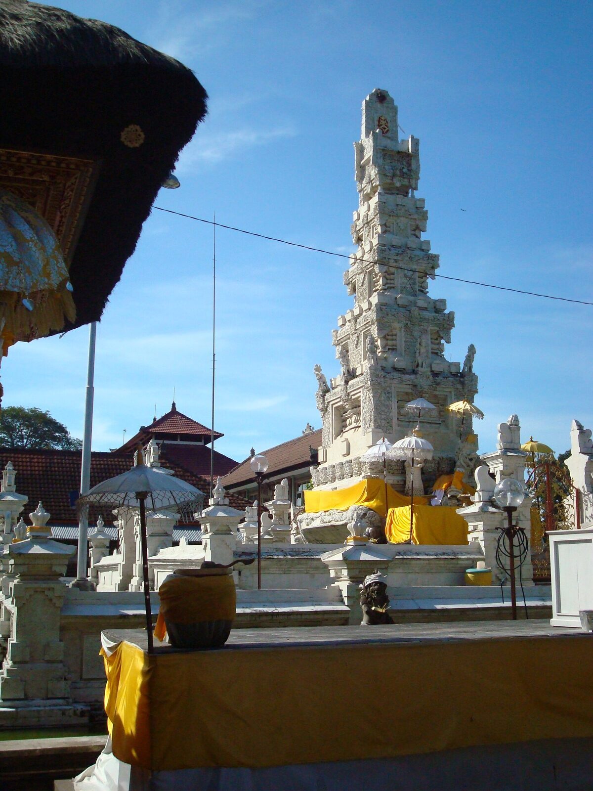 Offerings set out at the foot of the padmasana. The formless absolute, Acintya, is old; naming it the state-recognised 'one God' is what's recent.