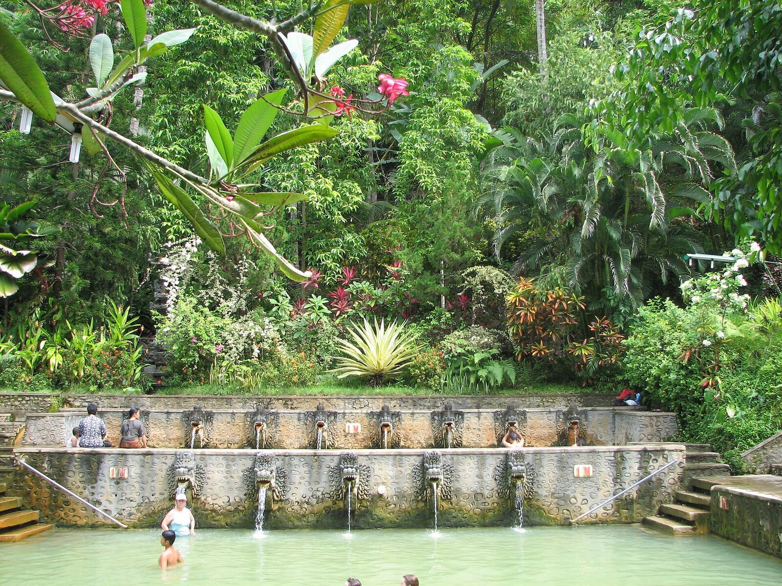 Spouts along the pool wall, with the hillside gardens rising behind.