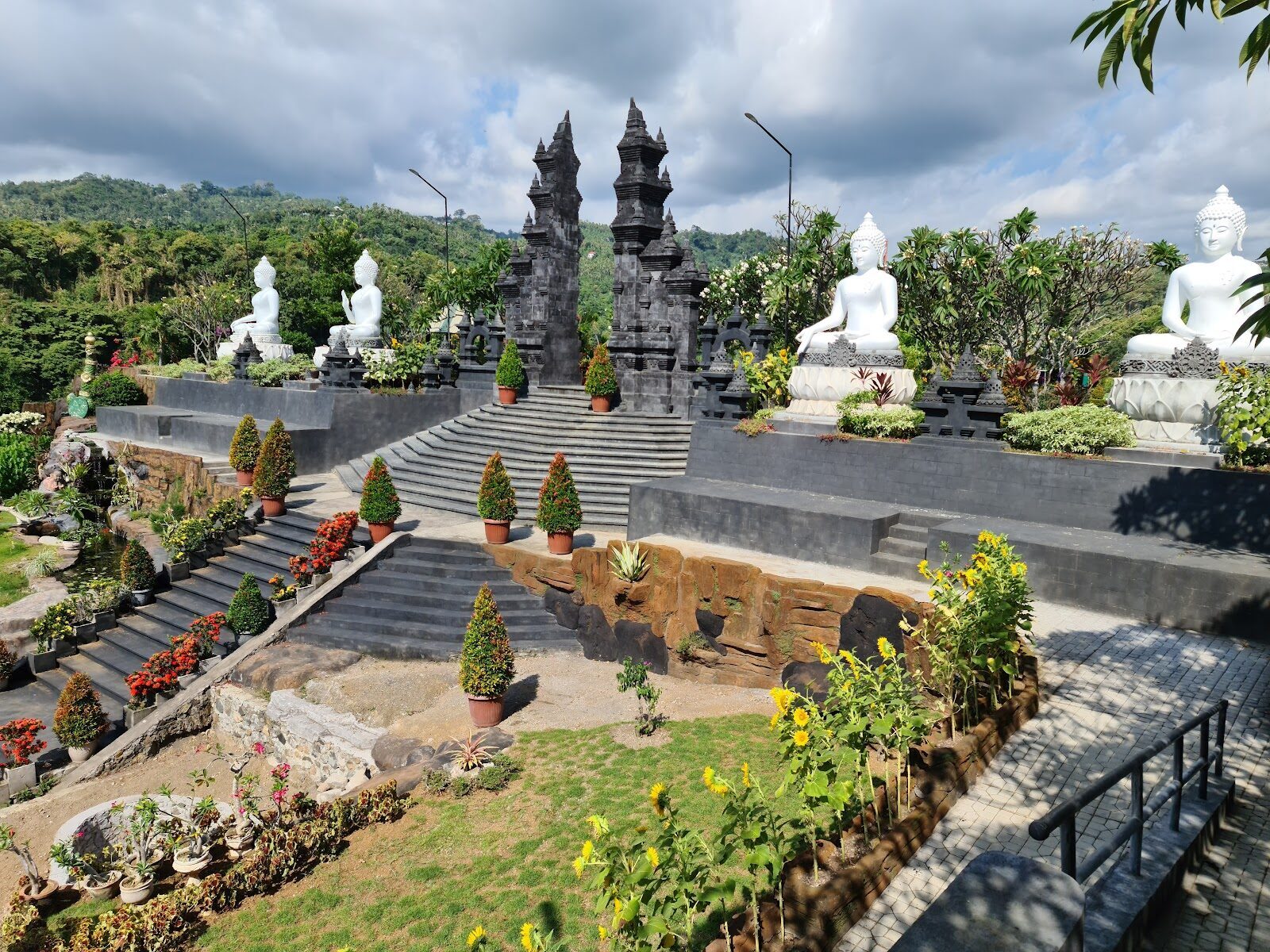 The terraced grounds with white Buddha figures and Balinese split gates.