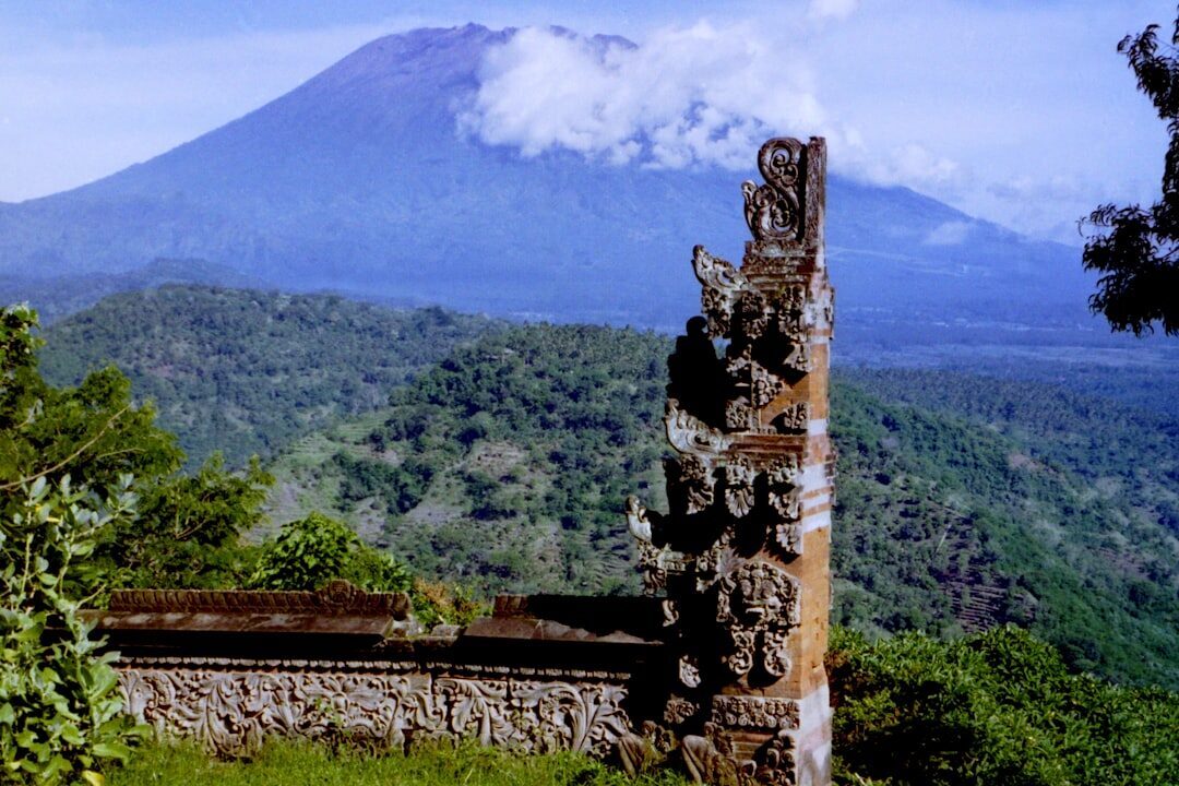 A carved Besakih gate against the bulk of Mount Agung.