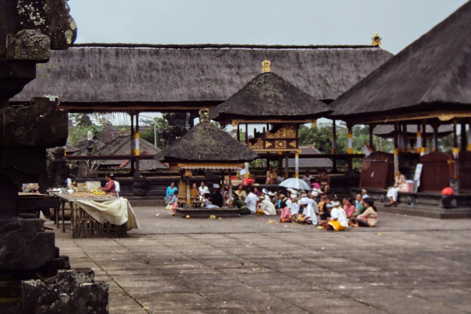 A quiet courtyard of thatched pavilions where worshippers gather.