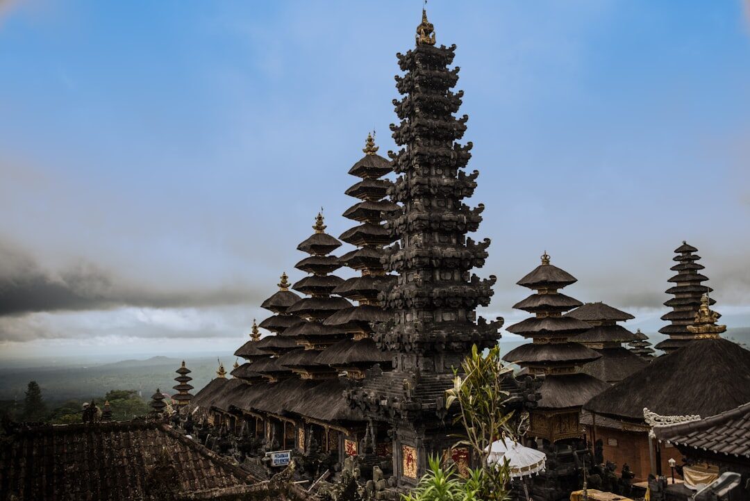 A tall meru tower with the East Bali hills falling away behind.