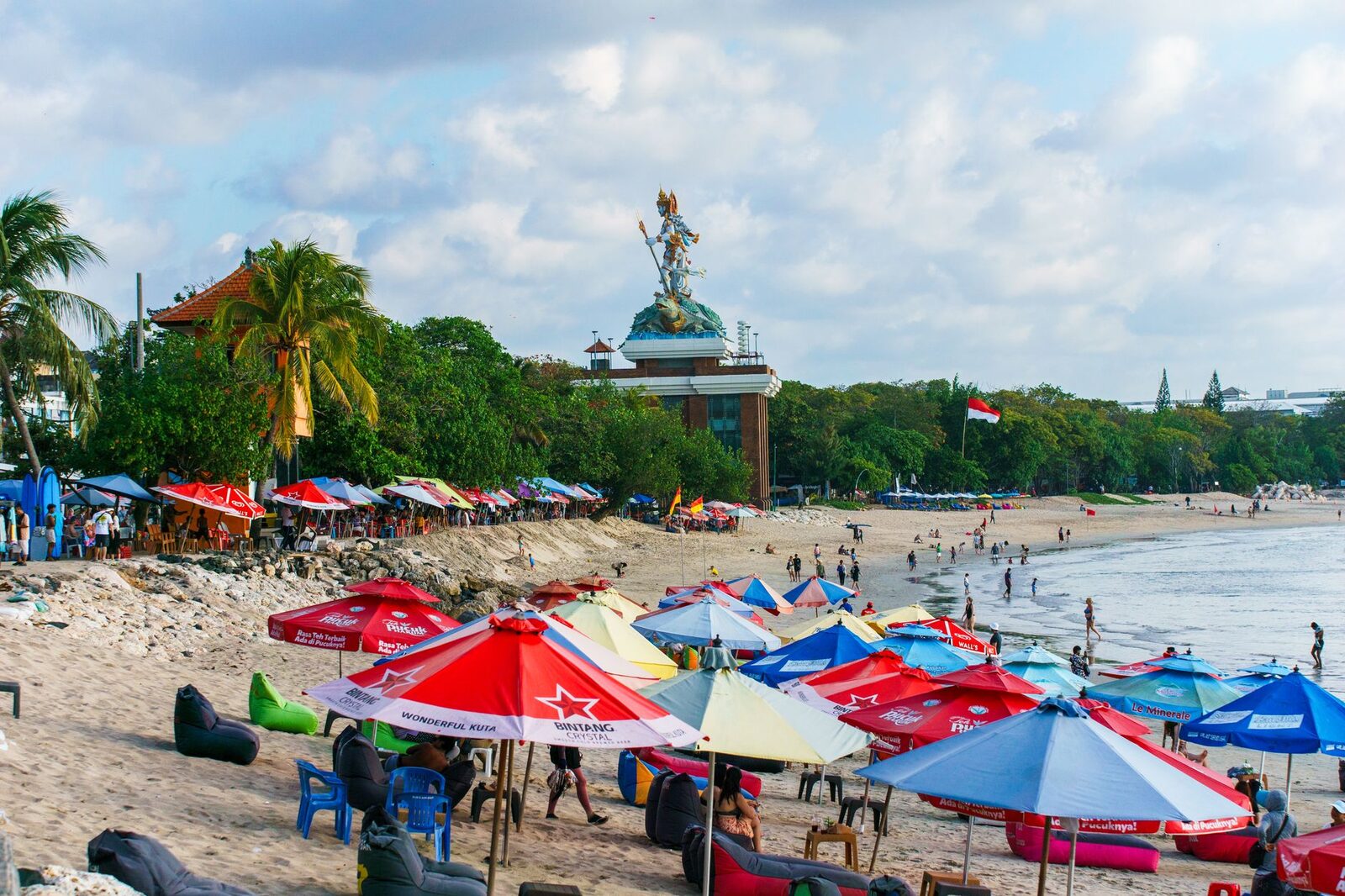 Rows of loungers and umbrellas along a busy resort beach.