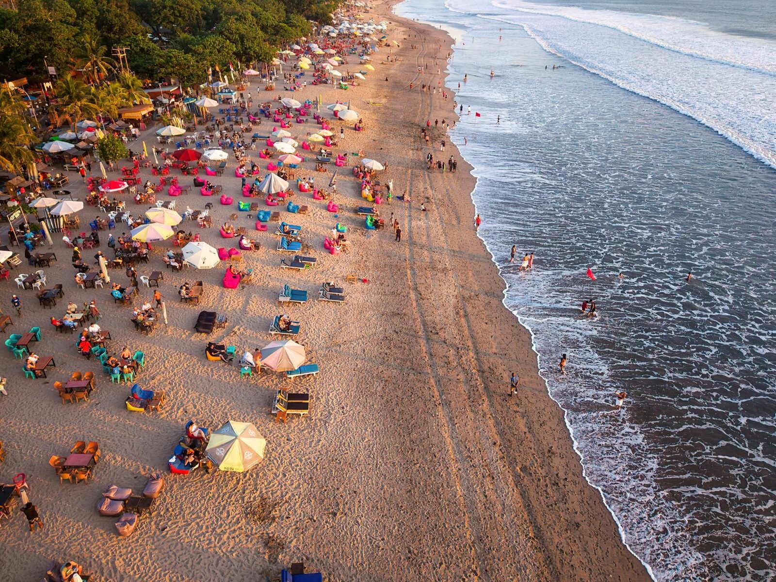 Peak season: a southern beach packed umbrella-to-umbrella — the crowds that arrive with the best weather in July and August.
