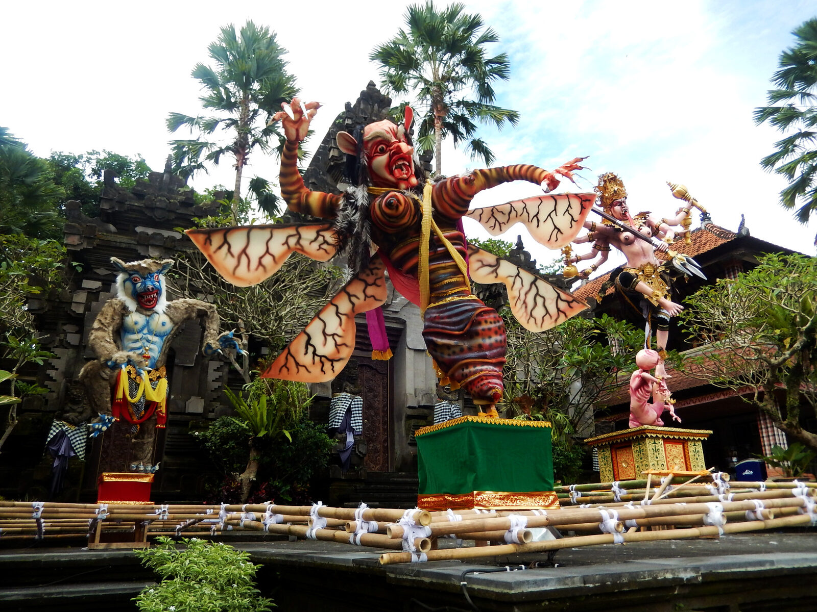 An effigy mounted on its float against a village backdrop before the procession.