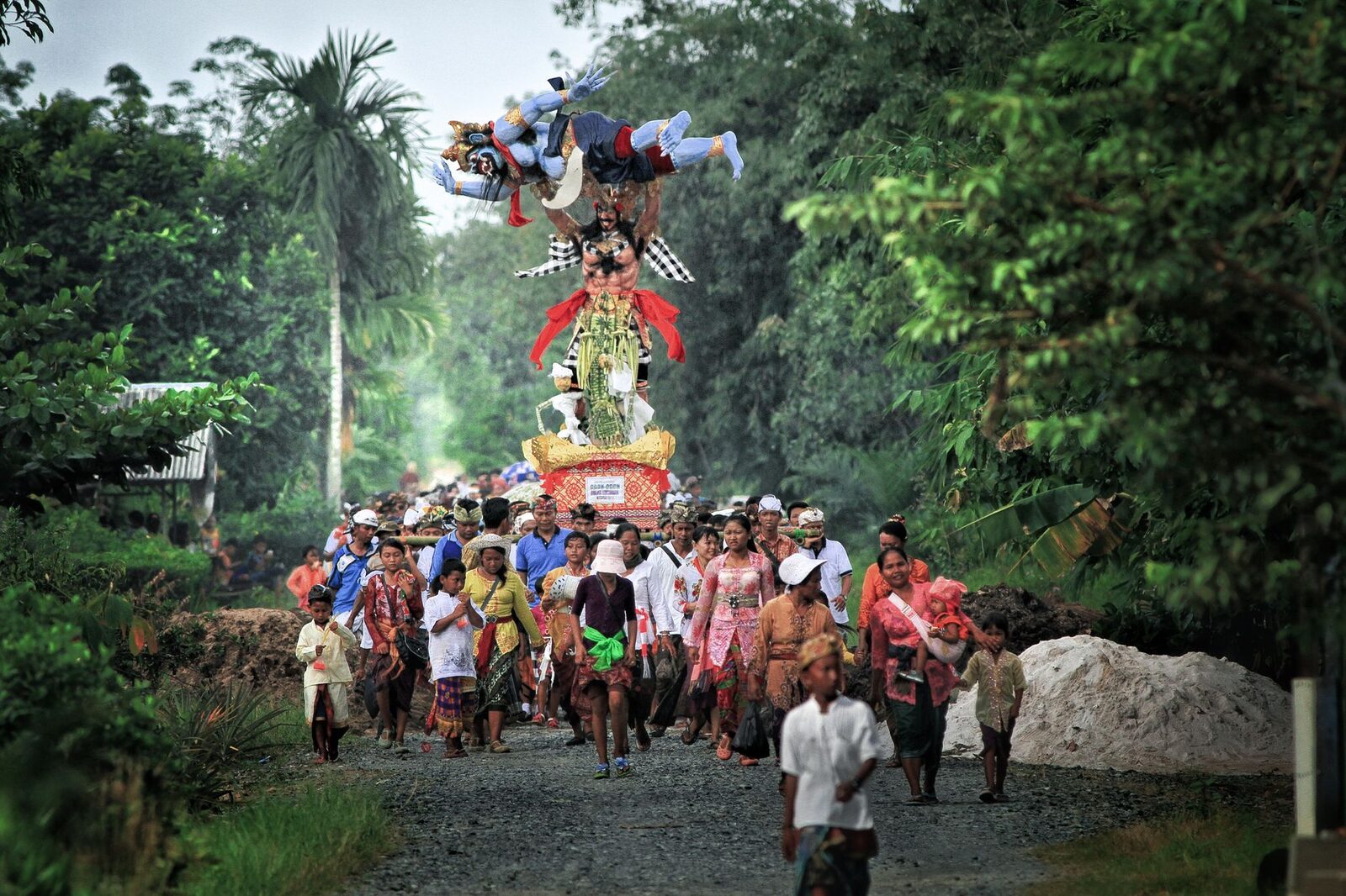 The parade moving through the village, the effigy towering over the crowd.