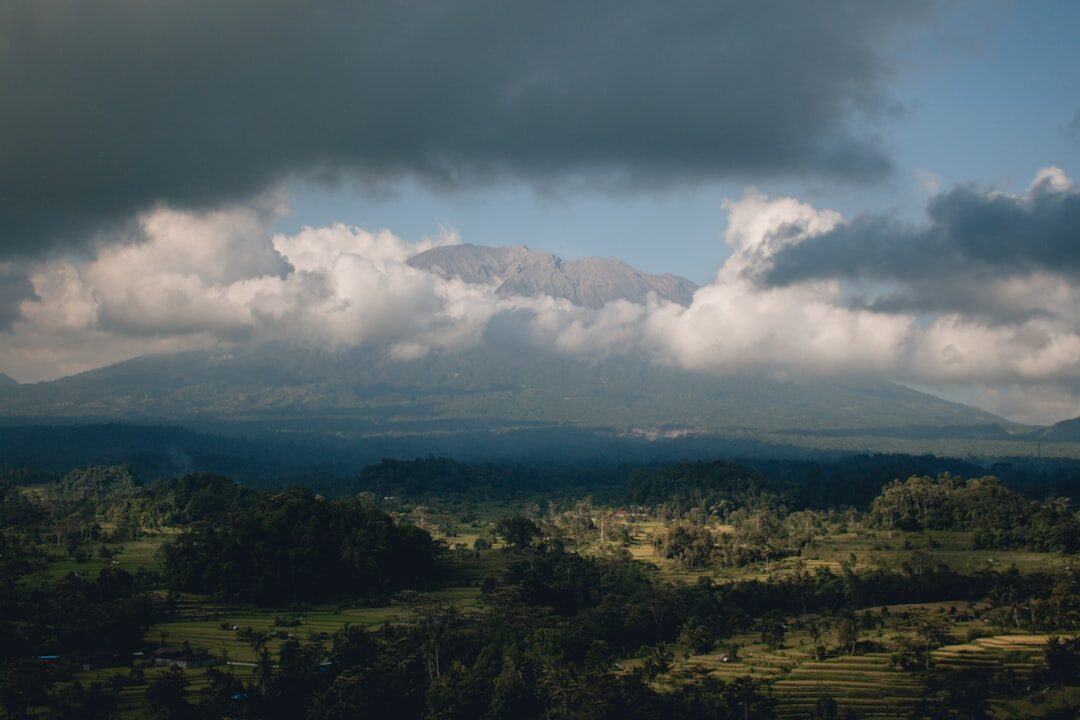 Green hills under towering wet-season clouds building through the afternoon.