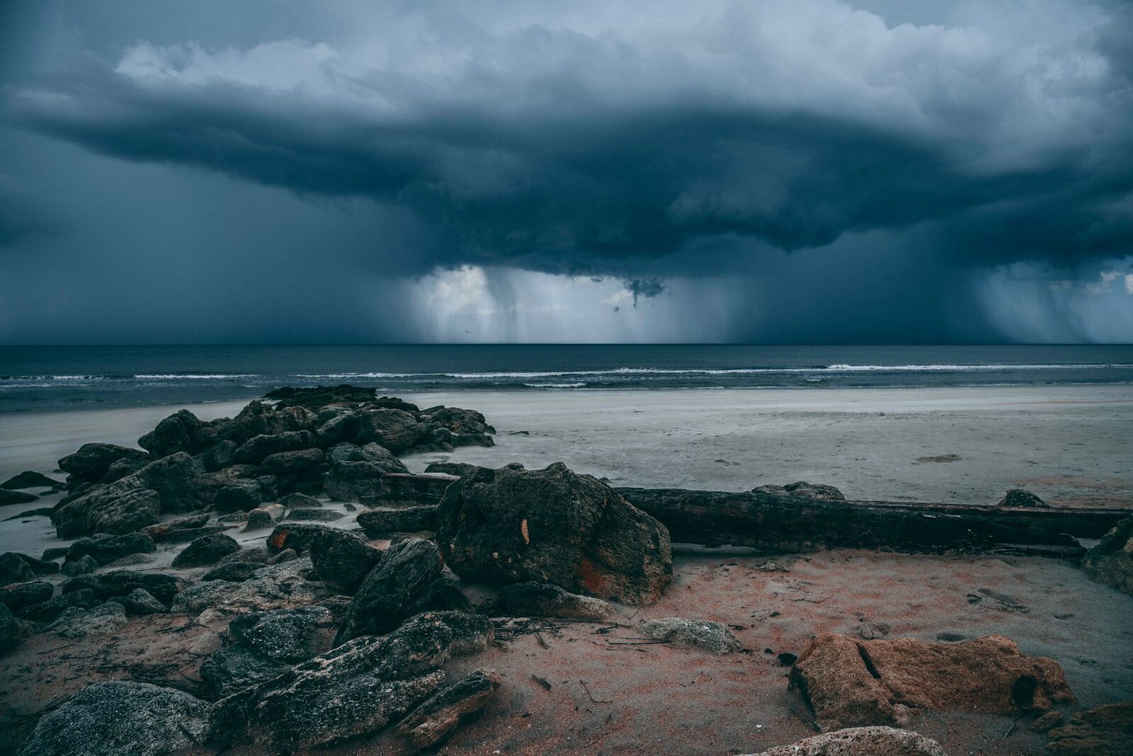 A storm cloud rolling in over the beach — the slate-grey afternoons that come with the wet months.