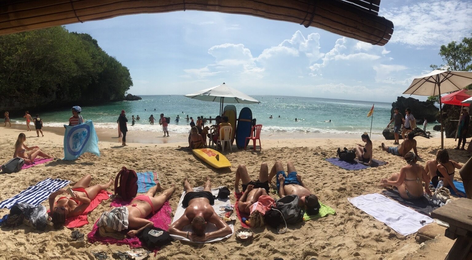 Padang Padang, reached down through a cleft in the rock — the sunbathers give the small cove its scale.