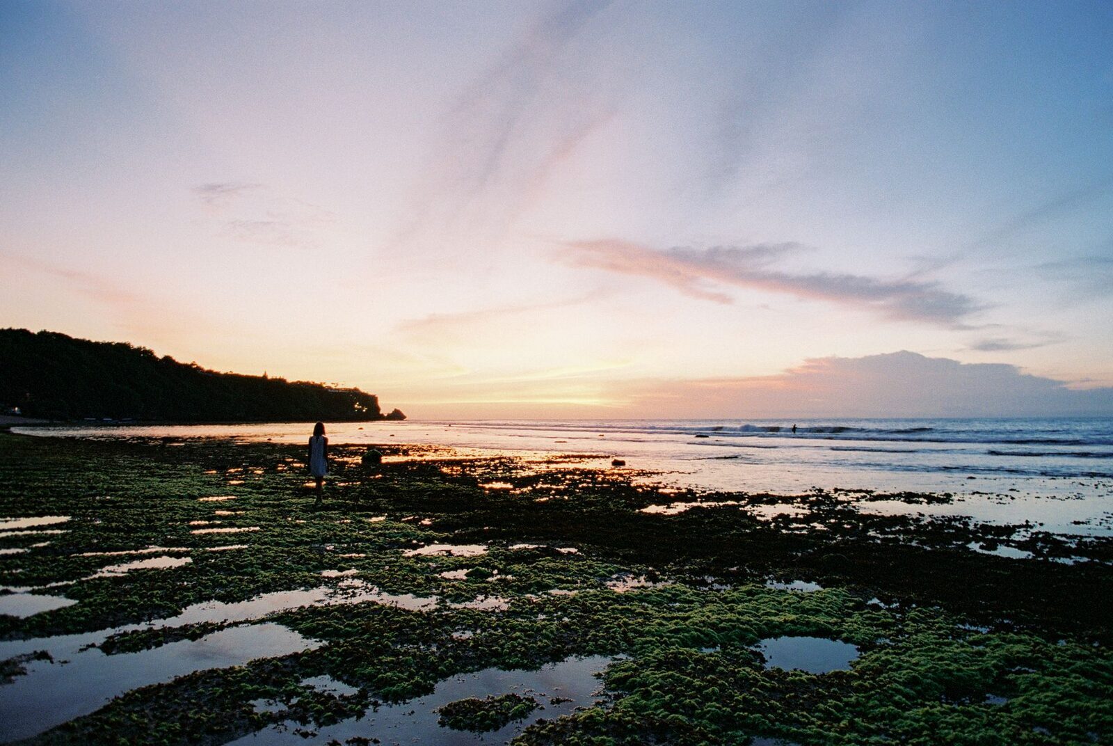 Low tide and sunset over the reef flat, the rock pools exposed.