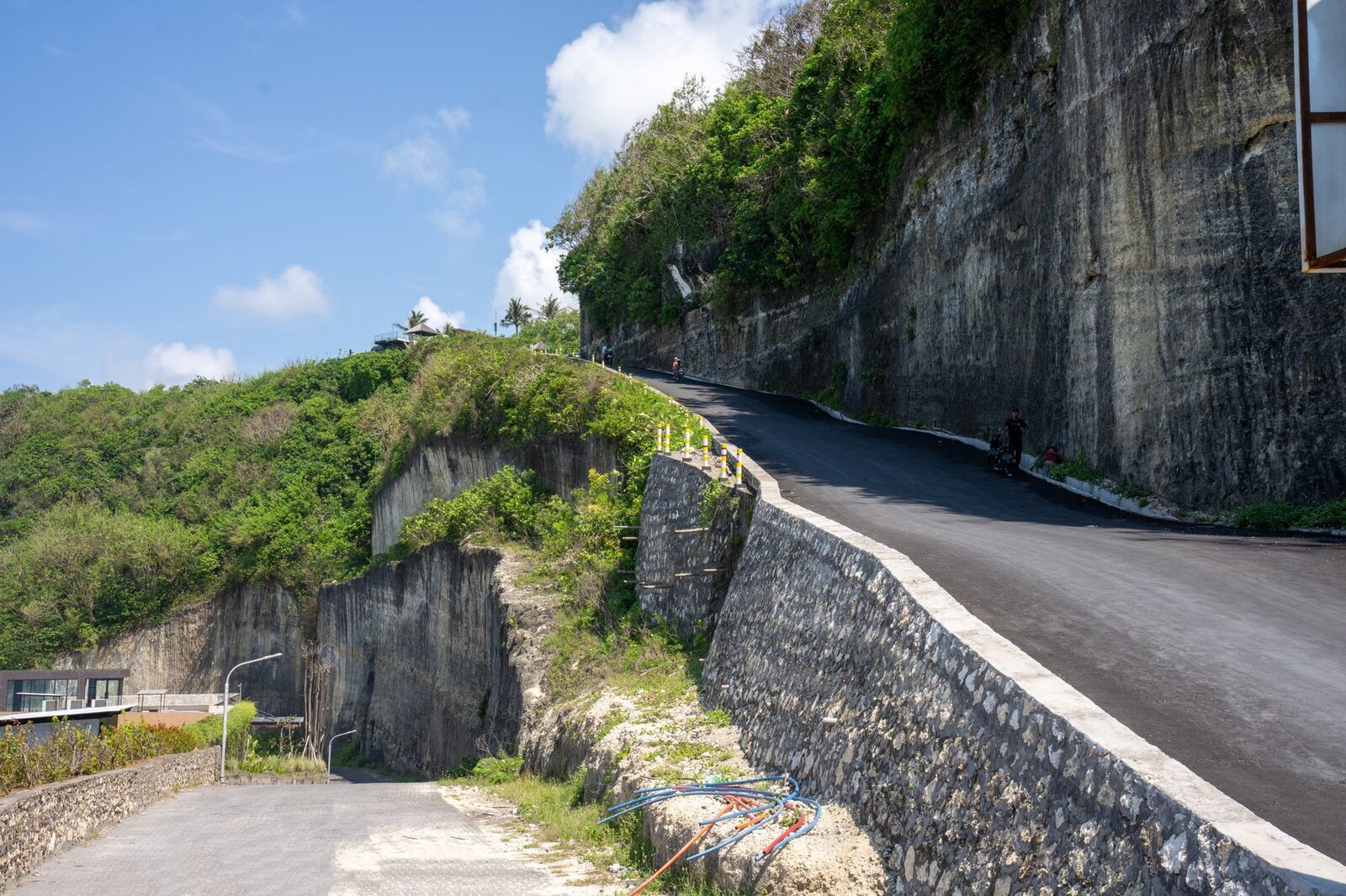 A single-lane road cut into the limestone hillside — short distances, slow going.