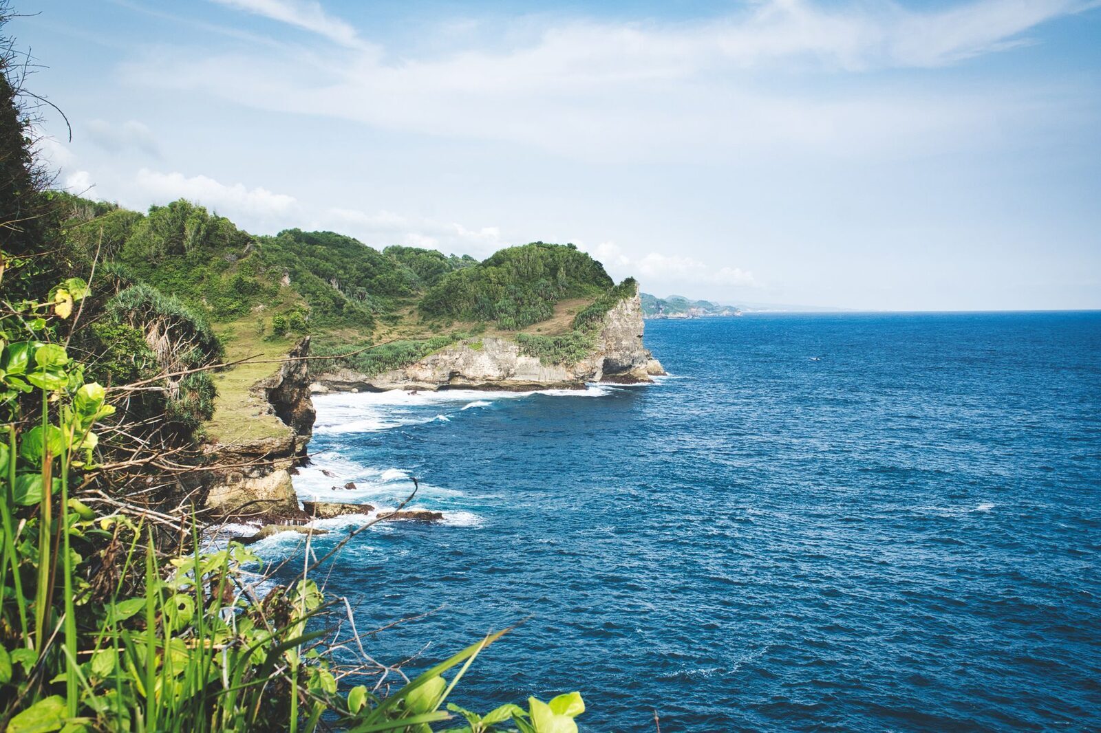 Green-topped cliffs and clear water along the peninsula's south coast.