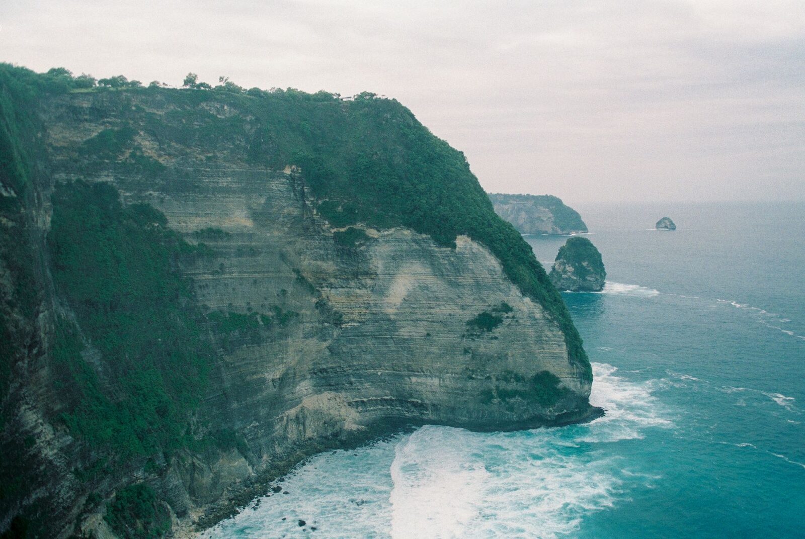 A reef-fringed limestone cliff and turquoise shallows.