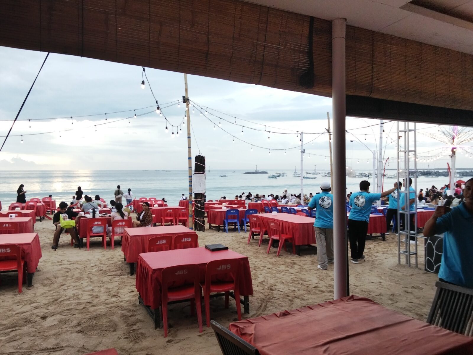Rows of tables laid out on the sand by day, waiting for the evening crowd.