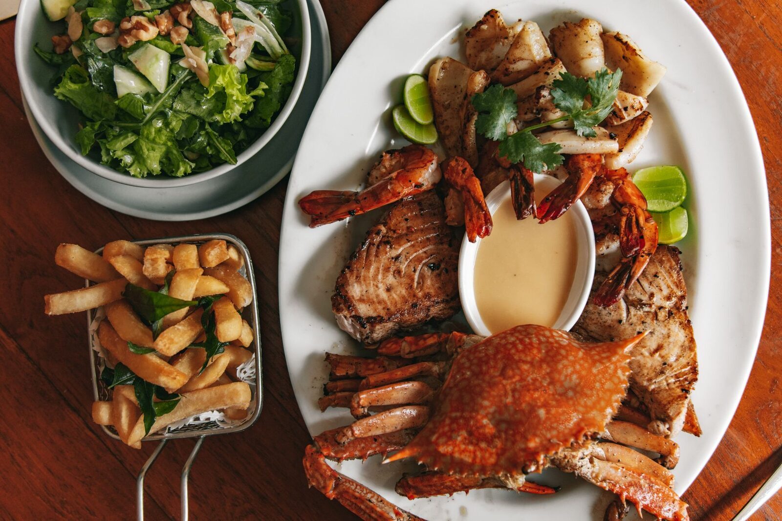 Grilled crab plated with sides and lime.