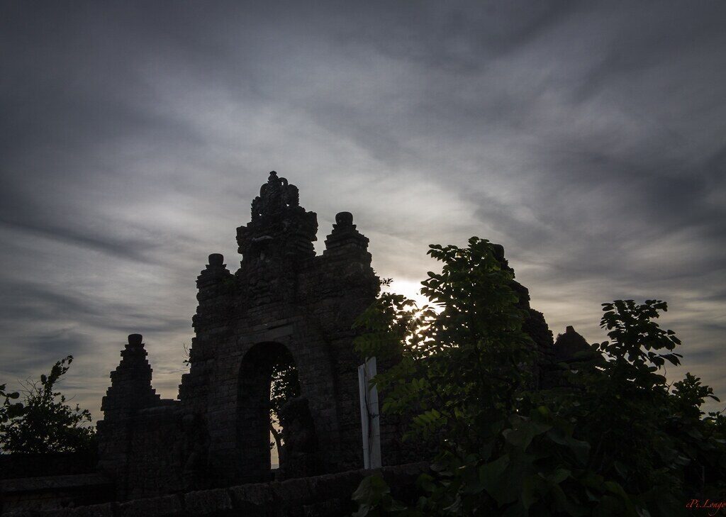 A split candi bentar gateway silhouetted against the dusk sky.