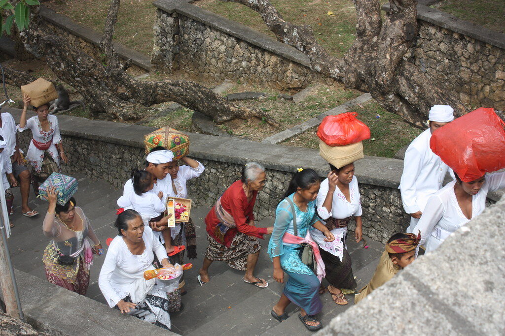 Worshippers in ceremonial white on the temple steps — this is a living Hindu temple, not just a viewpoint.