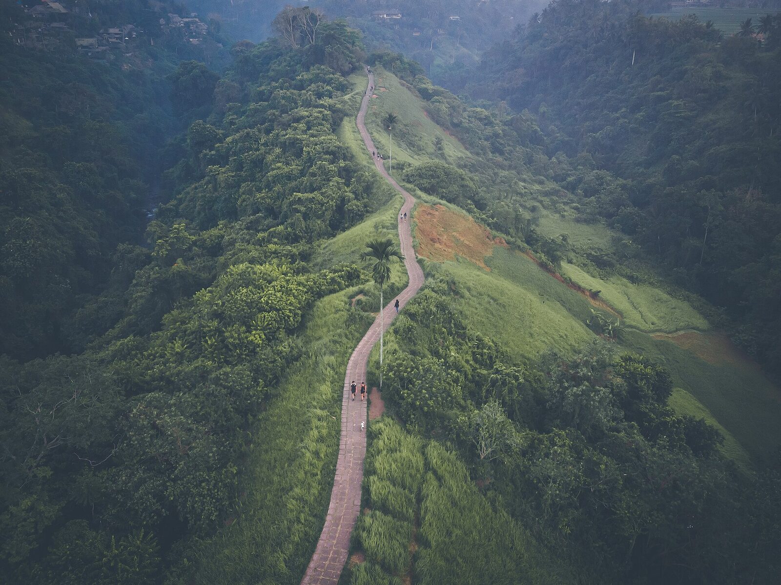 The ridge from above — the walkway snaking along the green crest between two valleys.