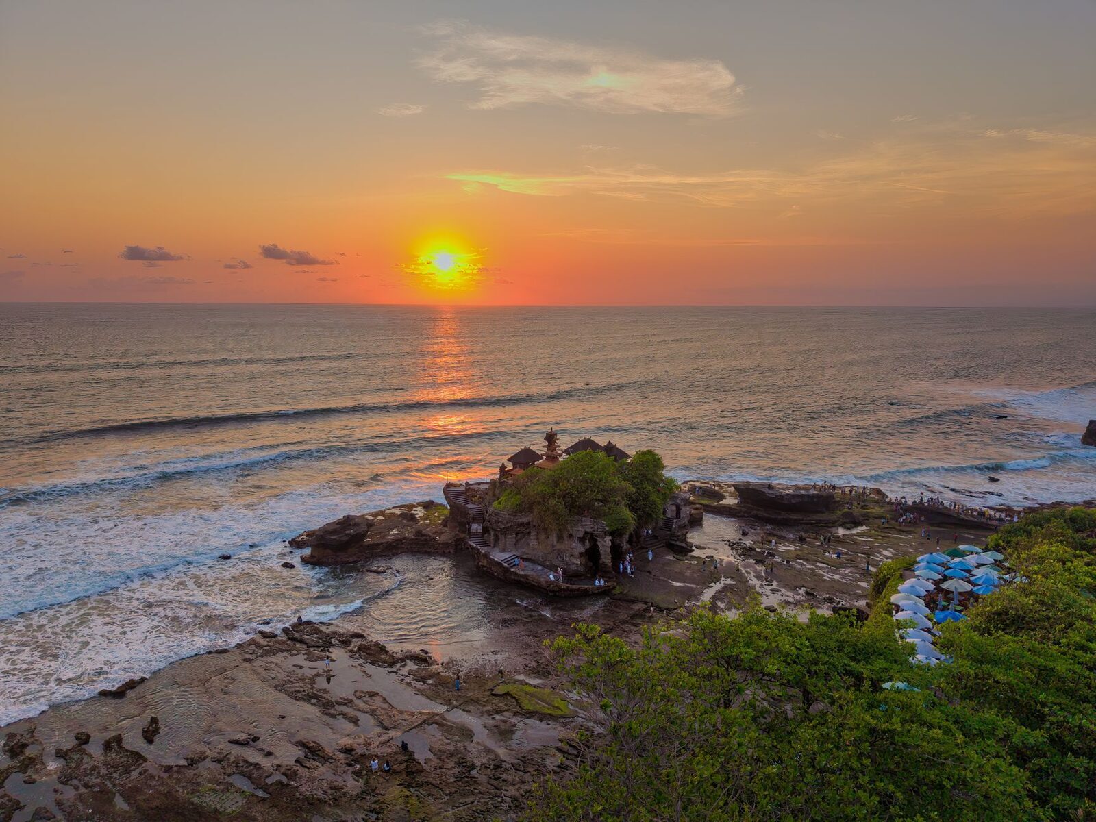 Sunset over the sea beside Tanah Lot — the reason the crowds come, and the reason it's worth timing.