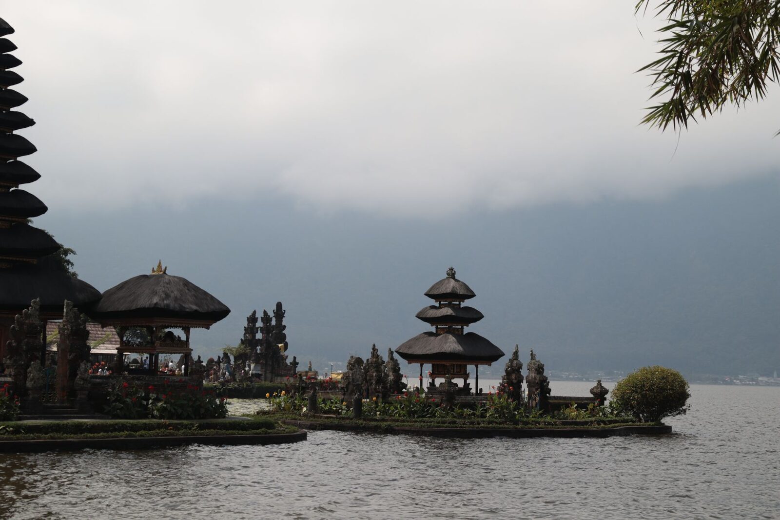 The temple half-lost in mist, the lake and the far crater rim behind it.