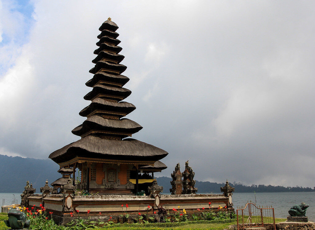 One of the tall thatched meru shrines close up, its black tiers stacked against the sky.